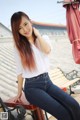 A woman sitting on top of a wooden bench.