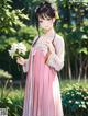 A woman in a pink dress holding a bunch of flowers.