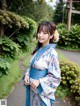 A woman in a blue and white kimono posing for a picture.