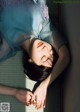 A woman laying on the floor with her eyes closed.