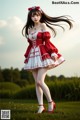 A woman in a red and white dress standing in a field.