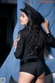 A woman in a police uniform leaning against a wall.